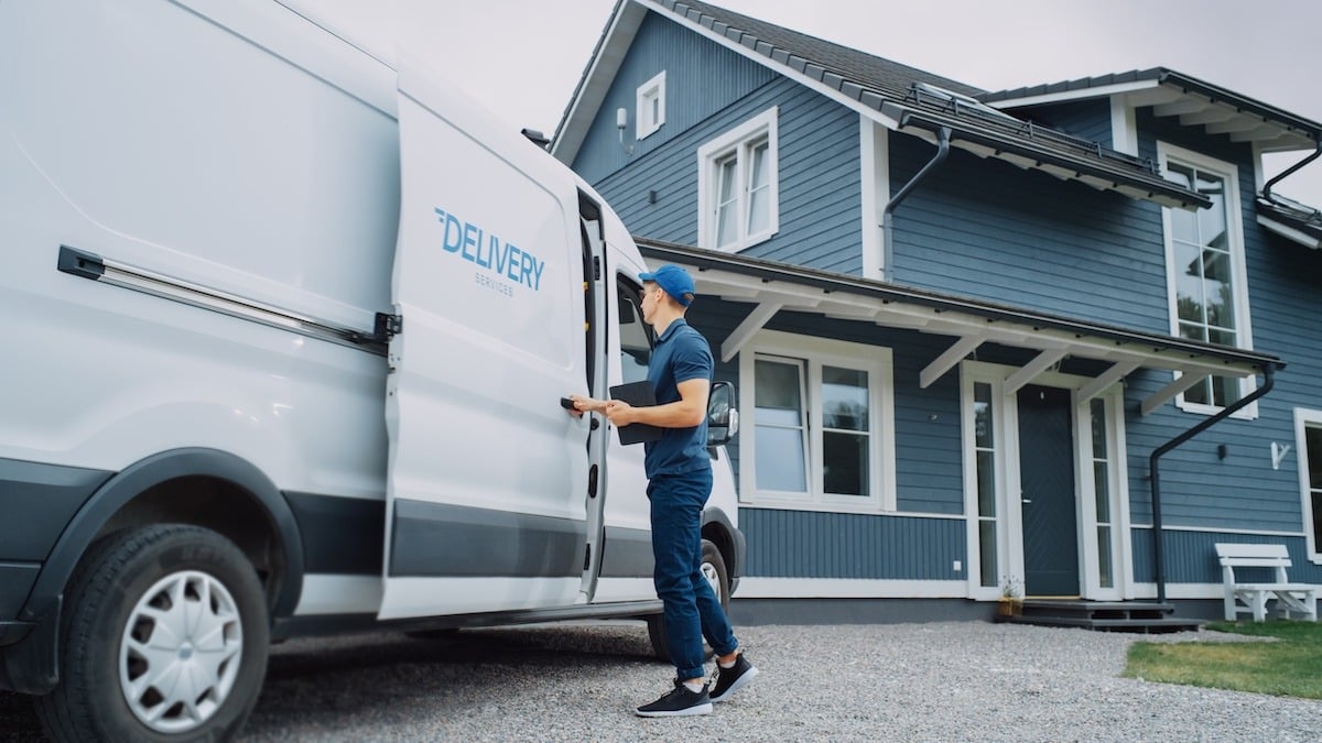 Delivery Driver Opening Door to White Delivery Van at a Residence