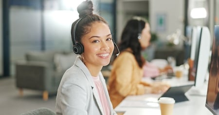 Sales and Customer Service Agent Talking on a Headset in Front of a Computer